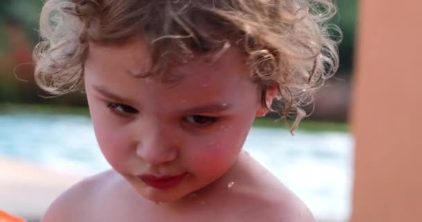 インフレータブルアームを身に着けている小さな男の子 スイミングプールでの幼児の肖像画 — ストック動画