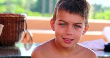 Portrait of handsome young boy child looking to camera outside after swimming pool