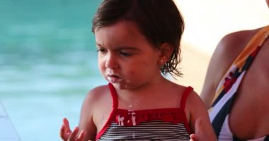 Ağzı yoğurtla kaplı üzgün küçük kız.