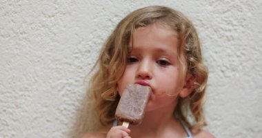 Çikolatalı dondurma yiyen küçük kız