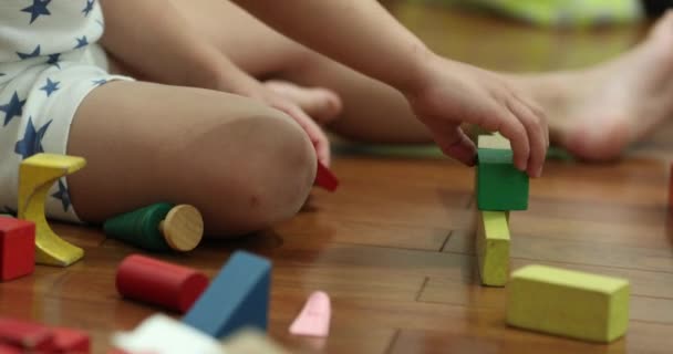 Child hands playing with wooden building blocks