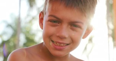 Portrait of handsome child smiling outside with lens-flare