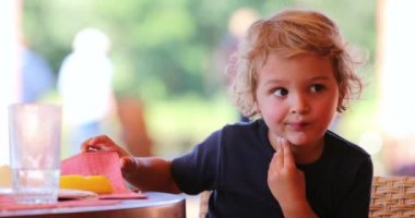 Candid blond little boy child outside