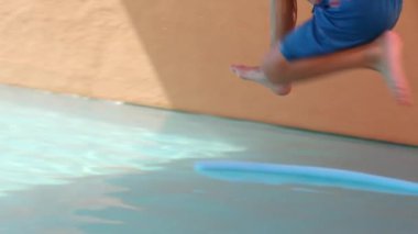 Küçük çocuk yavaş çekimde suya atlıyor.