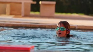 Küçük kız havuz suyunun içinde oynuyor