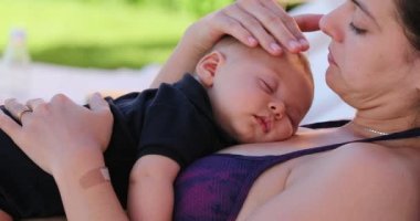 Candid Mother caressing baby infant by the swimming pool