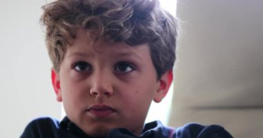 Child face portrait watching TV hypnotized