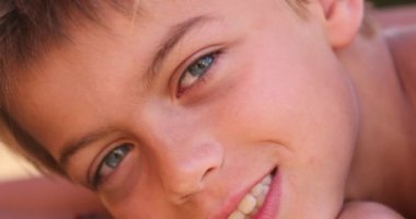 Handsome young boy face posing to camera smiling