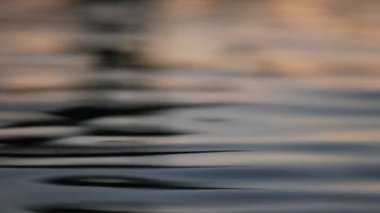 Liquid smooth lake water surface during sunset