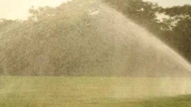 Water sprinkles watering lawn garden irrigation in slow-motion