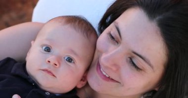 Happy mother and baby infant portrait faces looking to camera