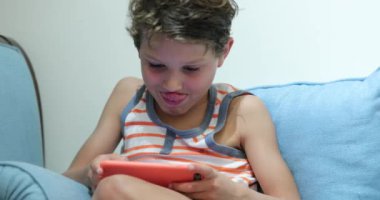 Child holding smartphone playing video-game at night
