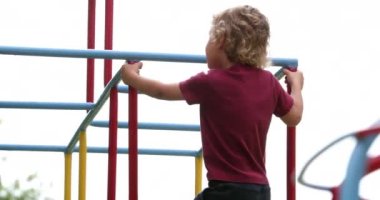 Children holding into monkey bars outside