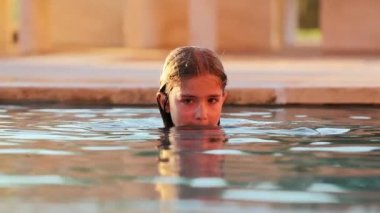 Yüzme havuzunda düşünceli, düşünceli küçük bir kız.