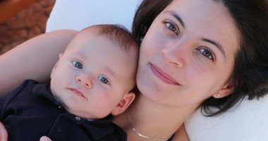 Portrait of mother and baby son faces looking to camera