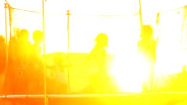 Çocuklar trambolinde zıplıyorlar altın saat günbatımı saatinde açık havada