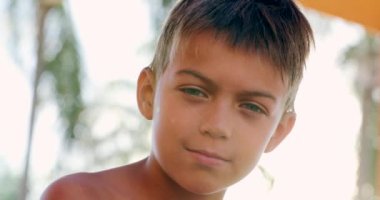 Portrait of serious handsome young boy looking to camera child face looks camera