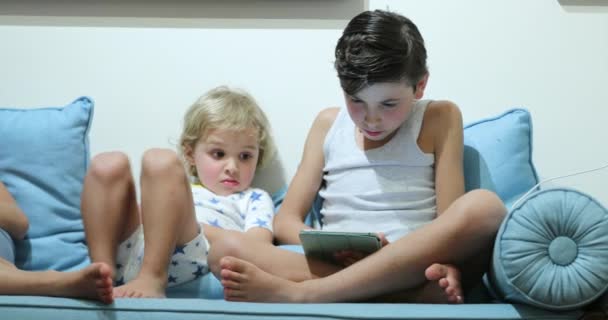 子供はビデオゲームをプレイするスマートフォンの赤ちゃんの弟は兄弟の画面を見て — ストック動画
