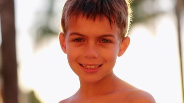 Portrait of handsome child young boy face looking to camera in the sunlight