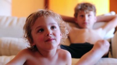 Samimi çocuklar film ekranına bakıyor çocuk yüzünü kapatıyorlar içerik eğlencesini izliyorlar