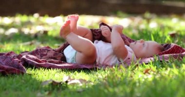 Baby infant laid on grass outdoors