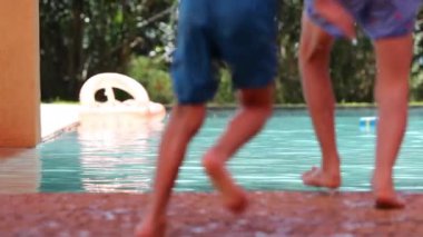 Çocuk havuz suyuna yavaş çekimde atlıyor.