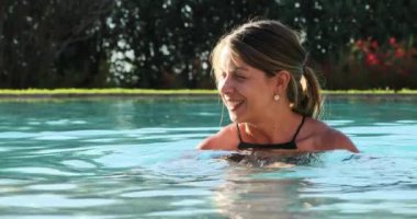 Havuz suyunda tatilin tadını çıkaran samimi bir kadın.