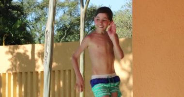Goofy Little boy dancing at the pool setting