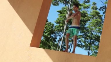 Çocuk platformda dans ediyor ve havuz suyuna atlıyor.