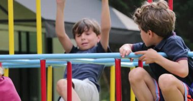 Children holding into monkey bars outside