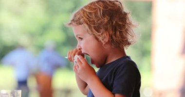 Child eating melong fruit dessert with spoon
