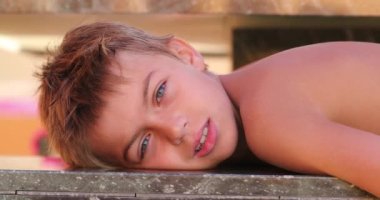 Small boy resting after pool laying down