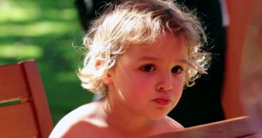 Cute blonde toddler child outside candid