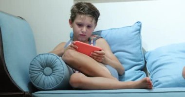 Child holding smartphone playing game at night