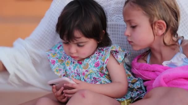Dwie Małe Dziewczynki Zahipnotyzowane Przez Smartfona Zewnątrz Dzieci Oglądające Kreskówki — Wideo stockowe