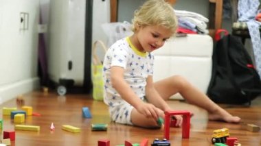 Boy playing with building structure blocks alone