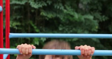 Young boy playing in monkey bars outside