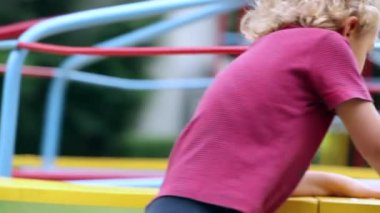 Toddler spinning around in carousel in playground