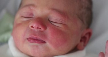 First day of life of newborn infant baby falling asleep