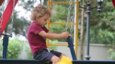 Infant young child playing at playground swing