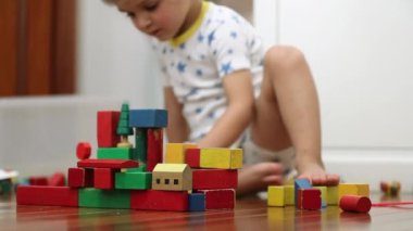 Toddler boy playing with building blocks toys