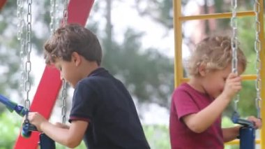 Children playing at playground swing outside