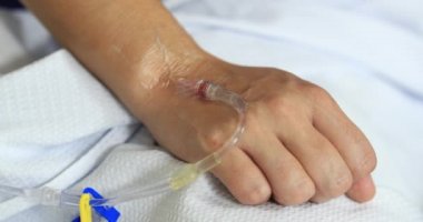 Close-up of hand connected to IV drip at hospital