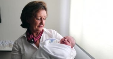 Grand-mother holding newborn baby infant grand-son