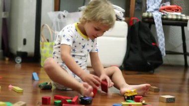 Toddler boy playing with building structure blocks alone
