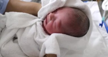 Drying newborn baby infant after bath at hospital