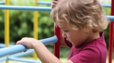Toddler baby infant playing in monkey bars at playground