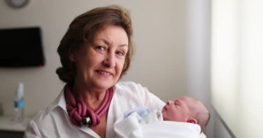 Grand-mother holding newborn infant baby in arms