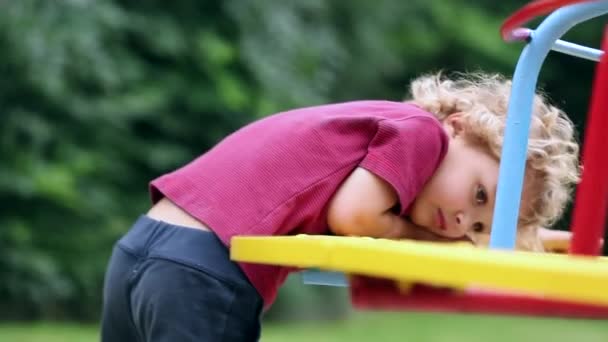 Boy Playing Playground Park Outdoors Holding Head Carousel — Stockvideo