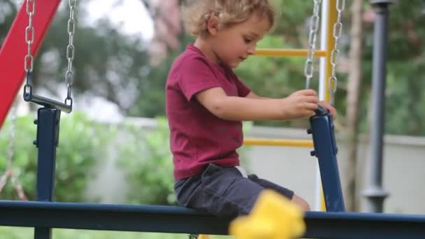 Child playing at playground swing outdoors